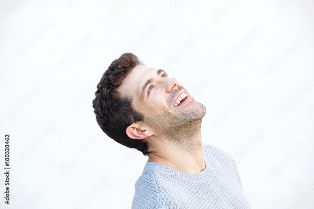 Obraz premium Close up young man looking up and laughing on white background