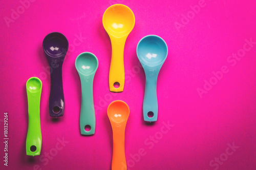 Colorful measuring spoons on  Purple background piece ingredient, kitchen equipment. copy space, top view