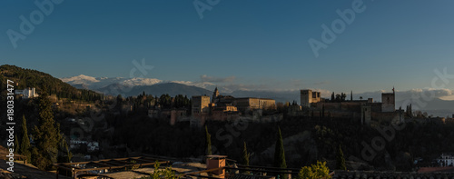 View of Alhambra Palace in Granada, Spain with Sierra Nevada mountains in snow at the background . Granada, Spain.