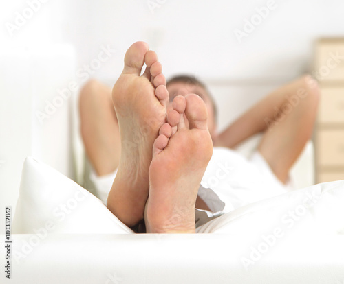 Young man relaxing and taking a break on sofa at home.