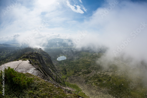 Heavy fog in the early morning on a mountain lake Early morning in the Ergaki national park, Russia