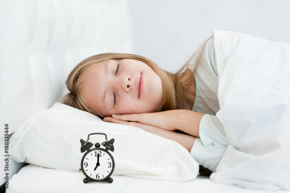 Adorable teen girl sleeping in bed with alarm clock Adorable teen girl sleeping in bed with alarm clock