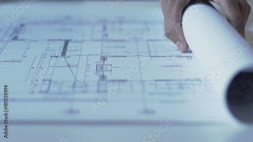 Hands of architect opening drawing of new building guidelines, design bureau