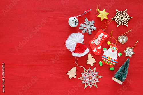Top view image of christmas festive decorations on red wooden background. Flat lay. © tomertu