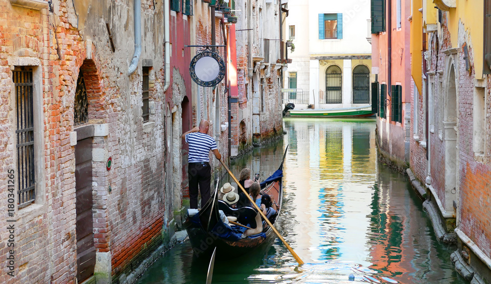 Venice, Italy. Tourists sail on a gondola on the canal