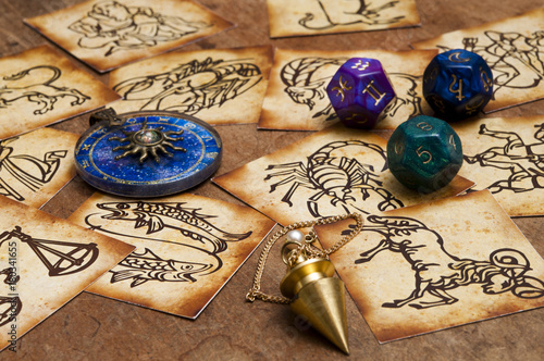 zodiac signs in old style with magic pendulum, blue horoscope ring and astrology dice 