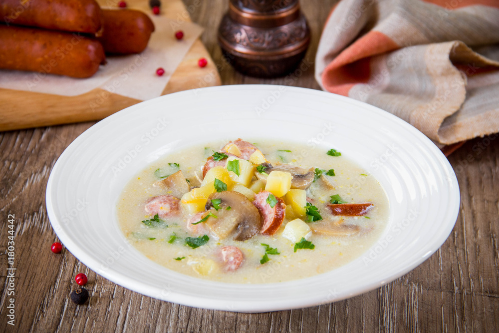 Cheese cream soup with mushrooms, potatoes, smoked sausage, German tasty dish Cheese cream soup with mushrooms, potatoes, smoked sausage, German tasty dish