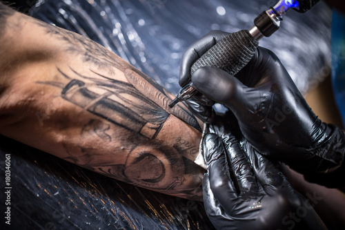 Hands of the artist tattooing © Grafvision