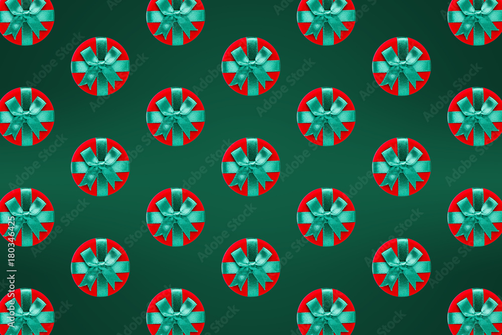Pattern of christmas and new year jewelry gift boxes on a green background Pattern of christmas and new year jewelry gift boxes on a green background