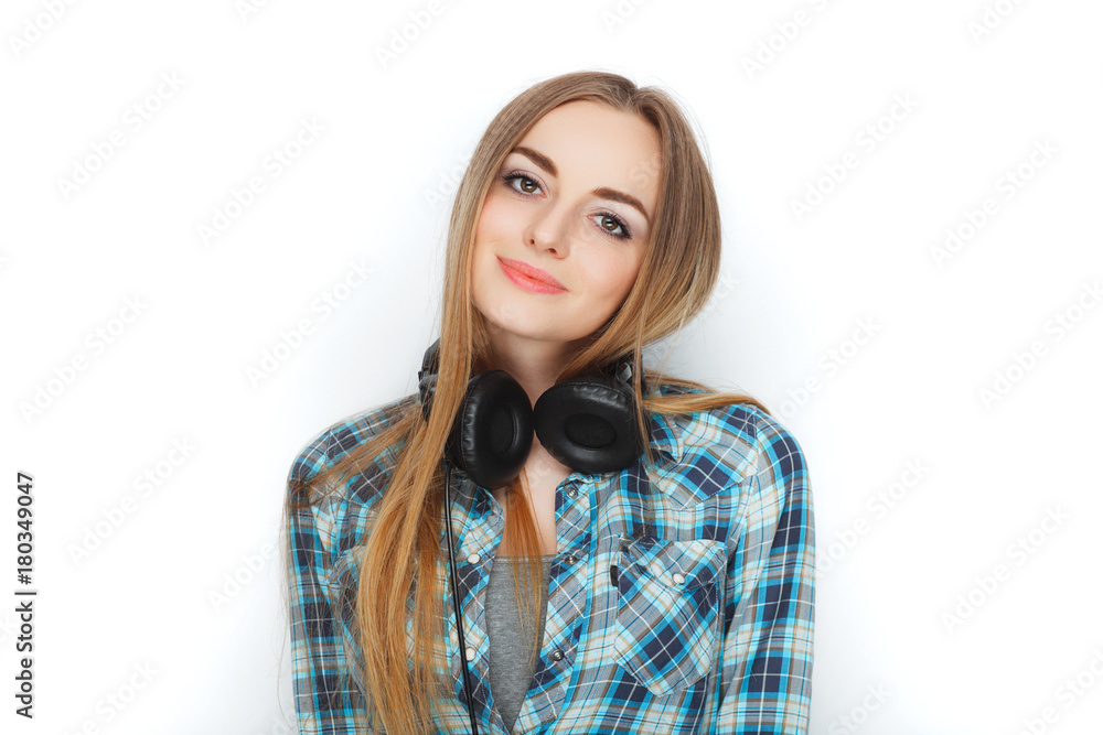 Headshot of a young adorable blonde woman in blue plaid shirt enjoying listening music to big professional dj headphones. Headshot of a young adorable blonde woman in blue plaid shirt enjoying listening music to big professional dj headphones.