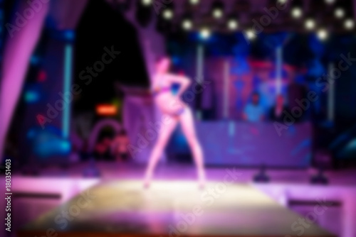 Blurred for background. Ibiza club fashion show. Nightclub show. Fashion show on stage with many in audience. Large crowd of people having fun in a nightclub during the show. © Alexey Lesik