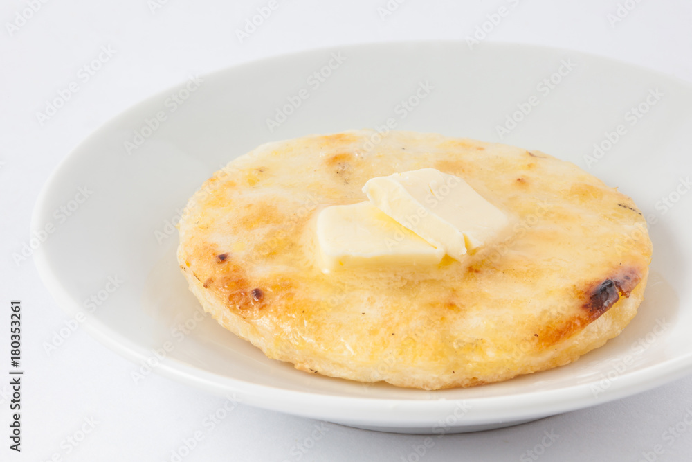 Traditional Colombian arepa topped with melted butter Traditional Colombian arepa topped with melted butter