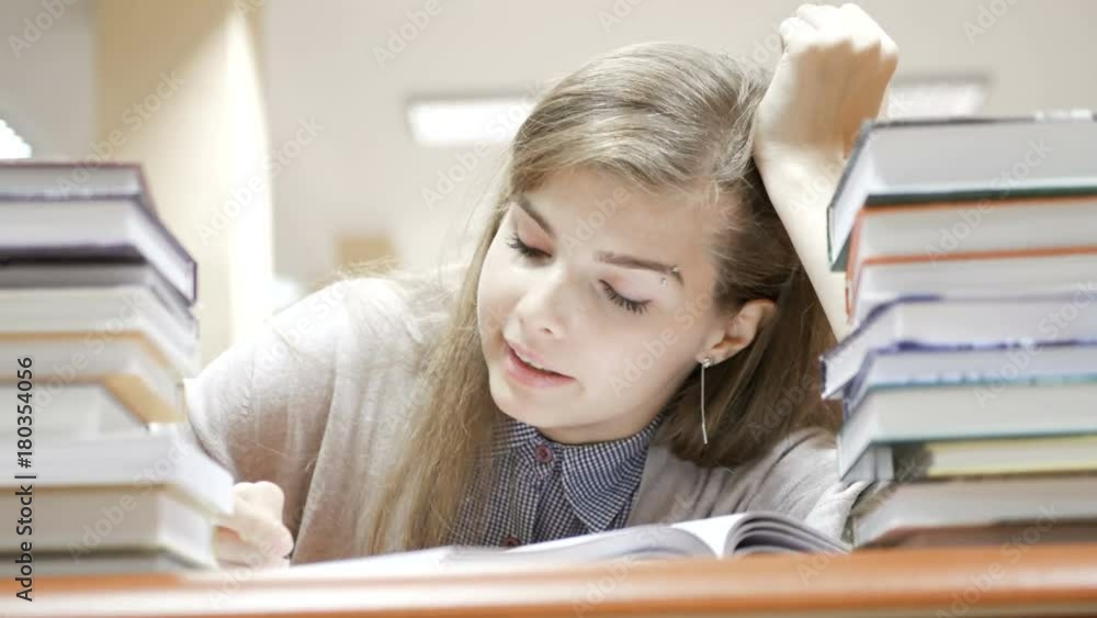 Female student falls asleep after been reading and studying all day in the library Female student falls asleep after been reading and studying all day in the library