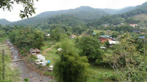 Small village in green valley, river, and mountain at Bo Kluea, Nan, Thailand, Time Lapse