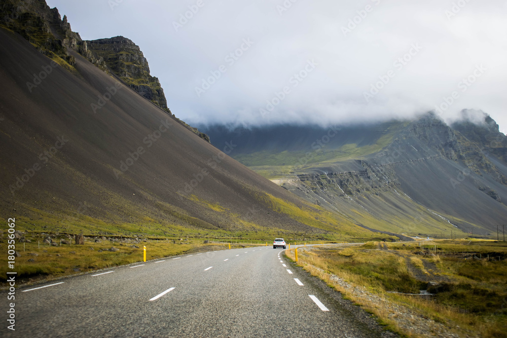Naklejka premium Driving the Iceland's Ring Road. Moving forward. Icelandic scenic landscape with mountains in the background.
