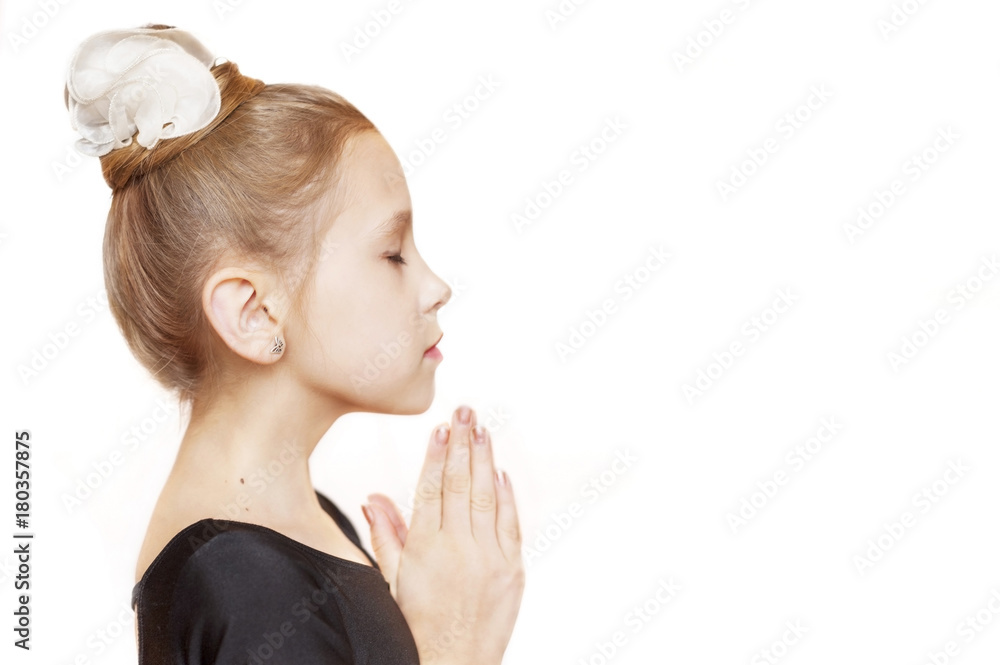 A young girl prays before a gymnastics competition on a white background A young girl prays before a gymnastics competition on a white background