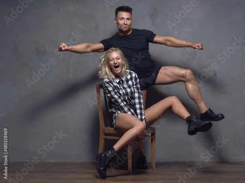 A young guy and a pretty girl are having fun and dancing.