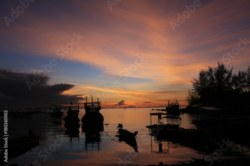 sunset with boats on the beach silhouette