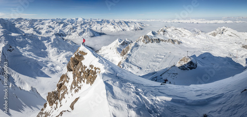 Obraz na płótnie Mountaineer standing on a snow capped mountain summit w salonie