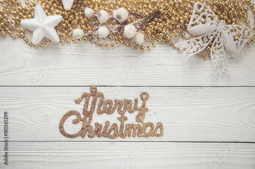 christmas background with holiday ornaments on white wood background with text: merry christmas