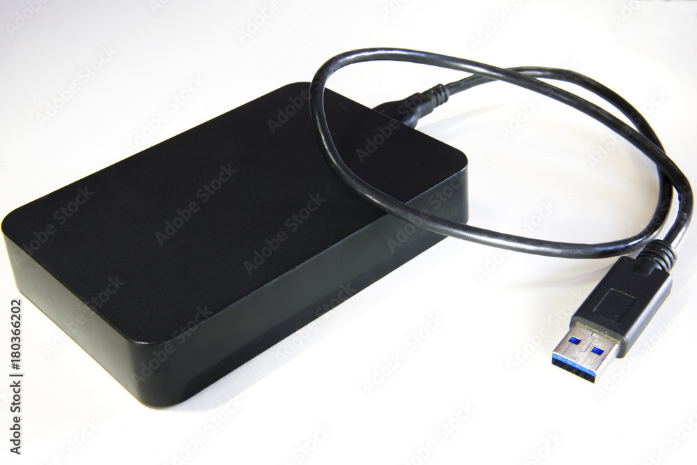 Dettaglio di un hard disk esterno di colore nero utile per l'archiviazione  dati. Presente anche il cavo con uscita USB da collegare al PC. Stock Photo  | Adobe Stock