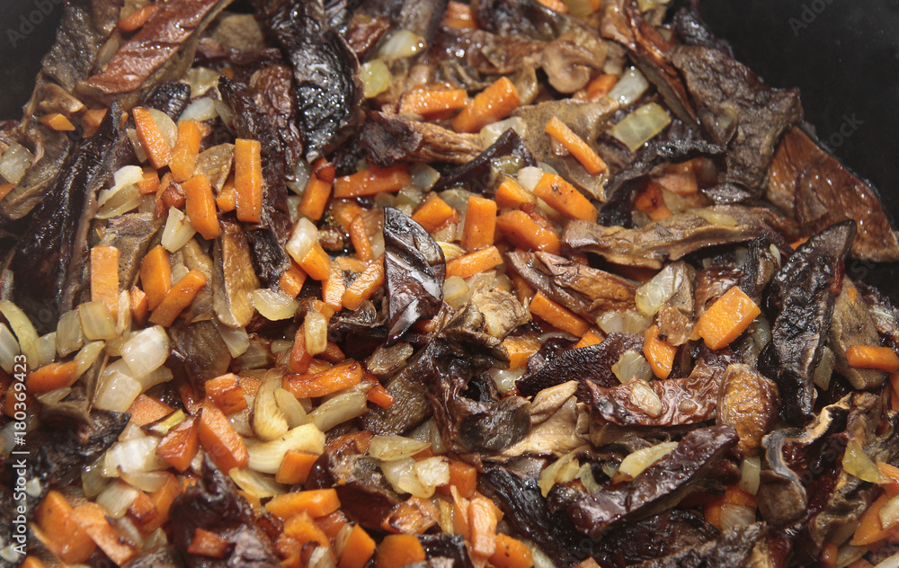Mushrooms fried on the pan with carrot and onion Mushrooms fried on the pan with carrot and onion