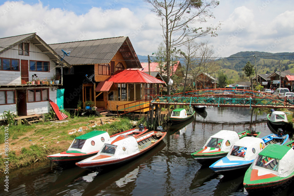 Obraz premium Colorful houses and boats parked on the side of the small river close to the Cocha lake, Colombia, South America