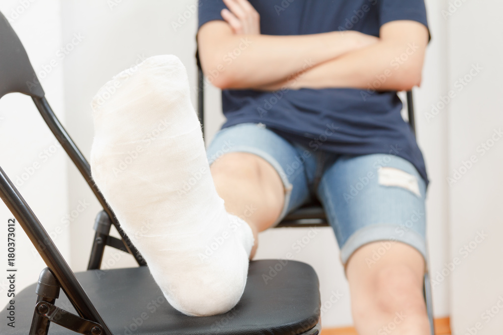Man with broken leg in a plaster on white background