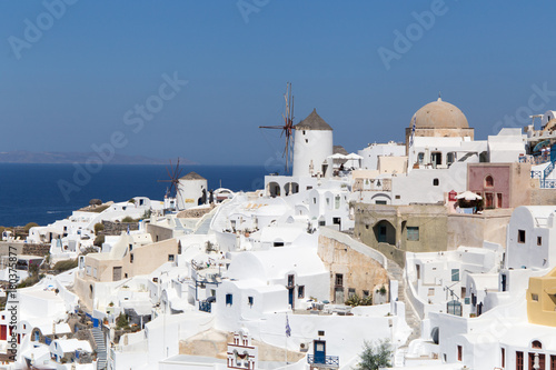 Landscape panorama with white houses and ancient wind mill in the Oia city in Greece