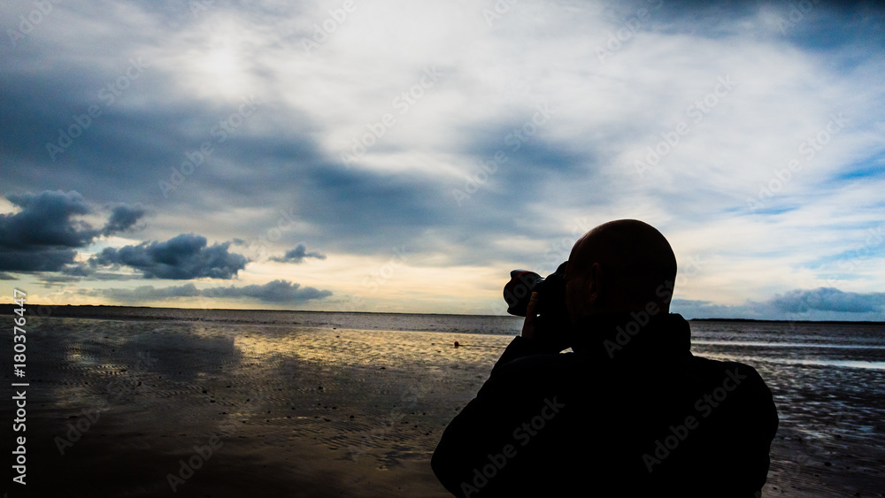 anonymous Passionate photographer shoots the landscape in moody silhouette.