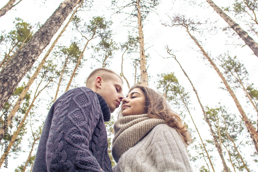 Fototapeta premium A guy and a girl look at each other embracing and holding hands. A young couple. St. Valentine's Day.