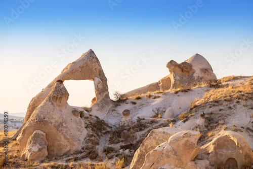 Volcanic tuff Rocks named fairy chimneys or mushrooms at sunset in Cappadocia, Turkey photo