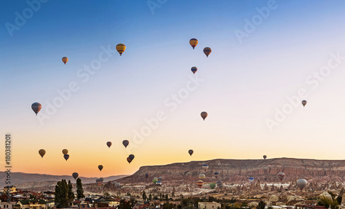 Many Hot air balloons flying over Goreme town in Cappadocia, panoramic view