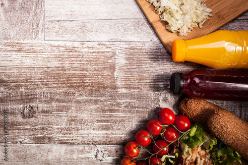 Delicious fresh grilled chicken on wooden board next to healthy bread, tomatoes and salad. Healthy lifestyle and eating