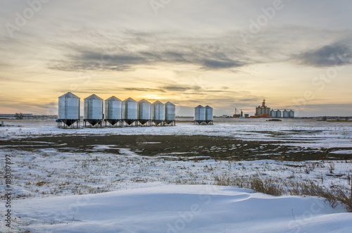 Metall barns and granaries in the snowy winter field