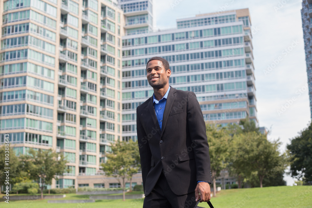 Young handsome African American man walking to work, looking confident and happy Young handsome African American man walking to work, looking confident and happy