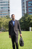 Good looking young African American business man in suits, commuting on foot