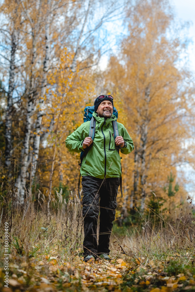 Mature backpacker in an autumn forest Mature backpacker in an autumn forest