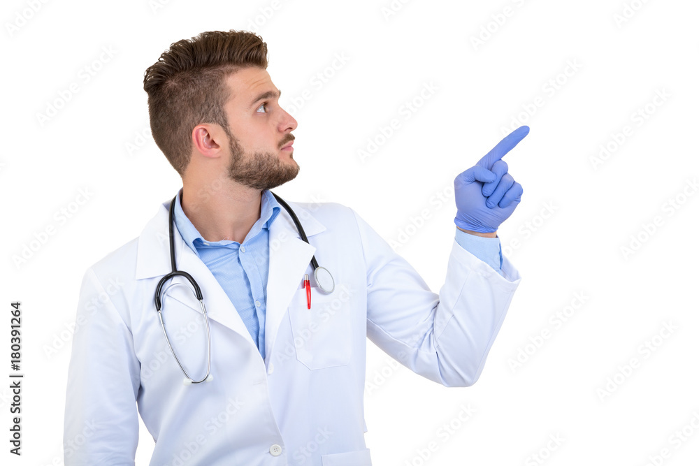 Portrait of a Young smiling male doctor pointing finger away isolated on a white background Portrait of a Young smiling male doctor pointing finger away isolated on a white background