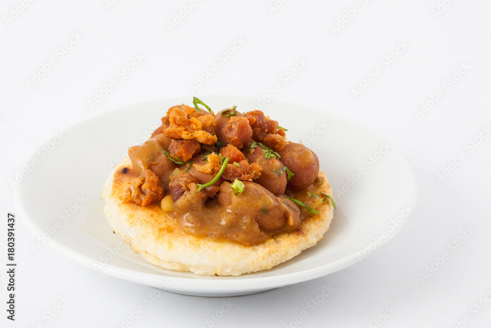 Traditional Colombian arepa topped with beans and pork rind Traditional Colombian arepa topped with beans and pork rind