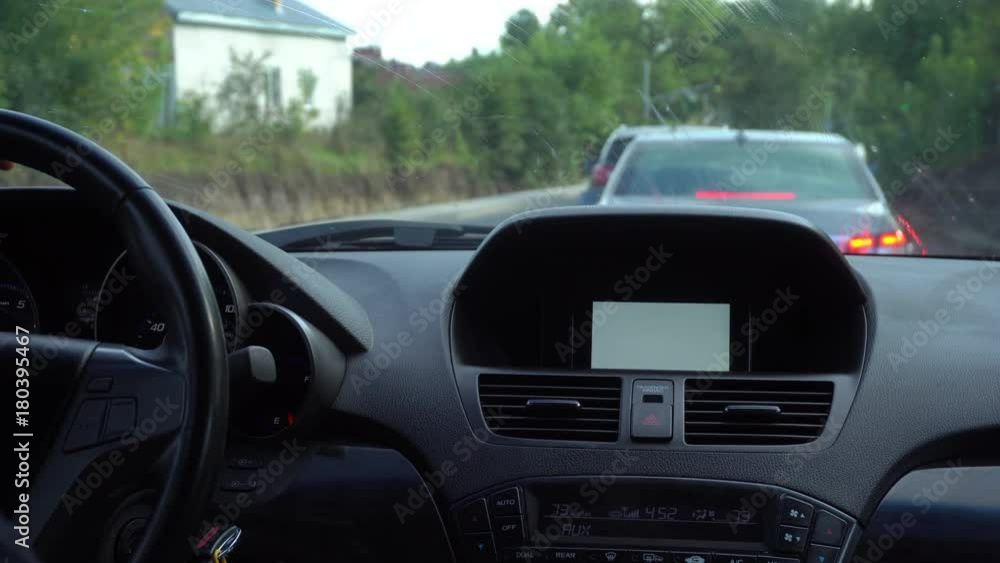 Inside a car. A GPS module is on. White screen. Close-up shot