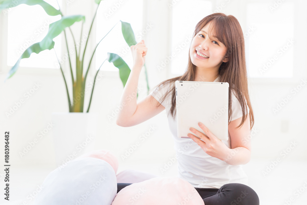 部屋でタブレットを見る女性 部屋でタブレットを見る女性