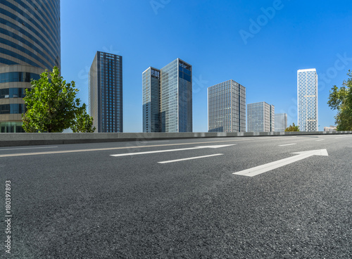 empty road and modern office block buildings against sky, china.