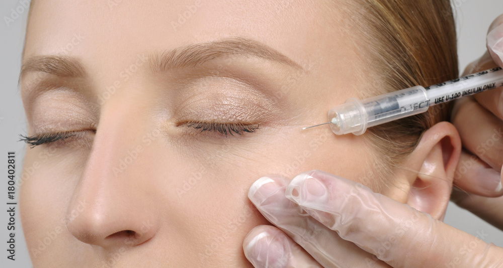 Woman is getting botox injection. Anti-aging treatment and face lift. Cosmetic Treatment and Plastic Surgery Woman is getting botox injection. Anti-aging treatment and face lift. Cosmetic Treatment and Plastic Surgery