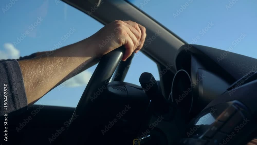 Inside a car. A man's hands on the steering wheel. Close-up shot Inside a car. A man's hands on the steering wheel. Close-up shot