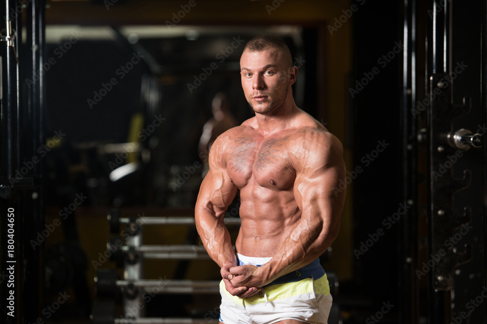 Handsome Muscular Man Flexing Muscles In Gym Handsome Muscular Man Flexing Muscles In Gym
