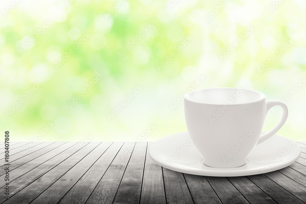 hot espresso with white ceramic coffee cup on wood table nature background blurred in garden.