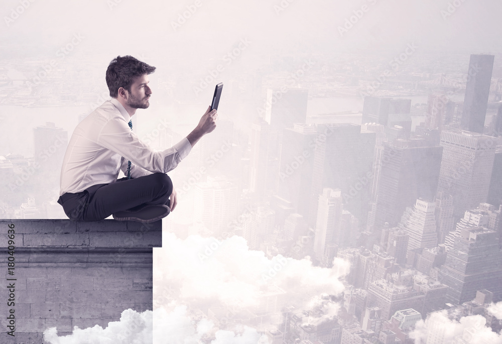 Sales person sitting on building edge in city Sales person sitting on building edge in city