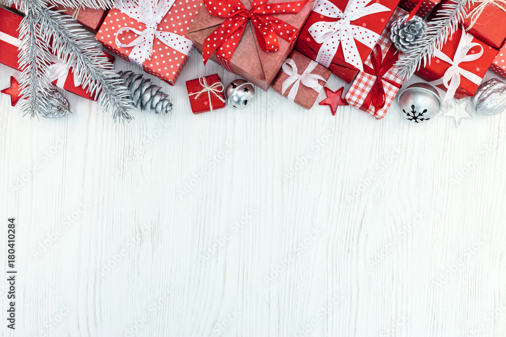 Obraz premium christmas red gift boxes, fir tree branches and silver decorations on wood background top view