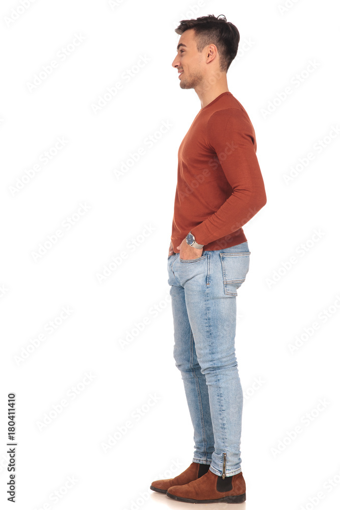 side view of smiling man standing with hands in pockets side view of smiling man standing with hands in pockets